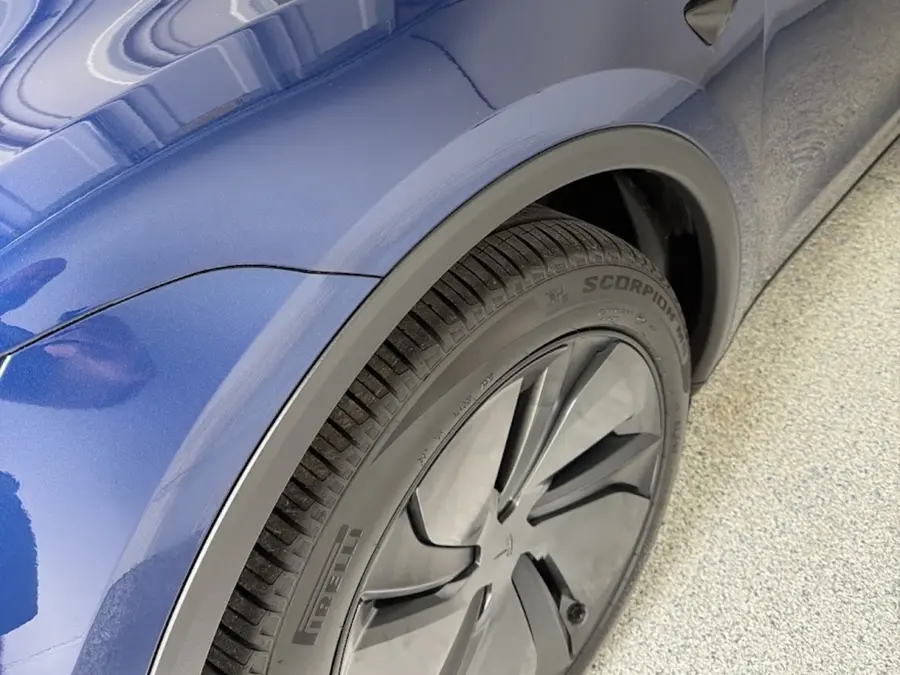 Close-up of a glossy blue exterior finish and wheel after a hand wash